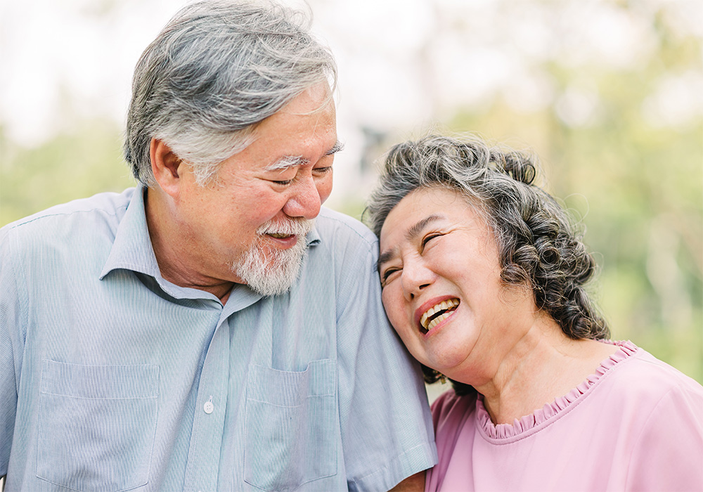 Couple walking outdoors smiling and leaning on each other